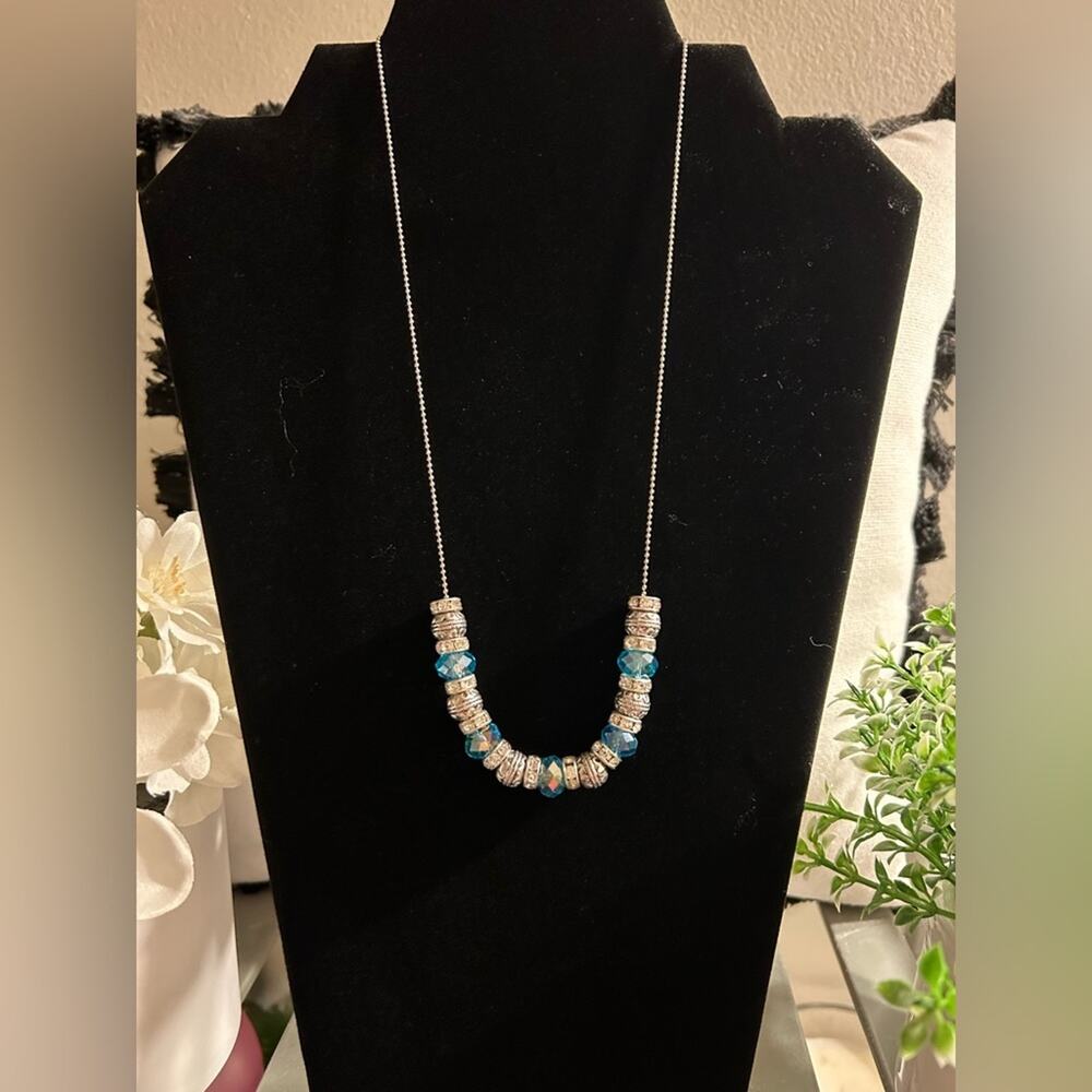 Silver necklace with silver charms, rhinestones and blue iridescent jewels